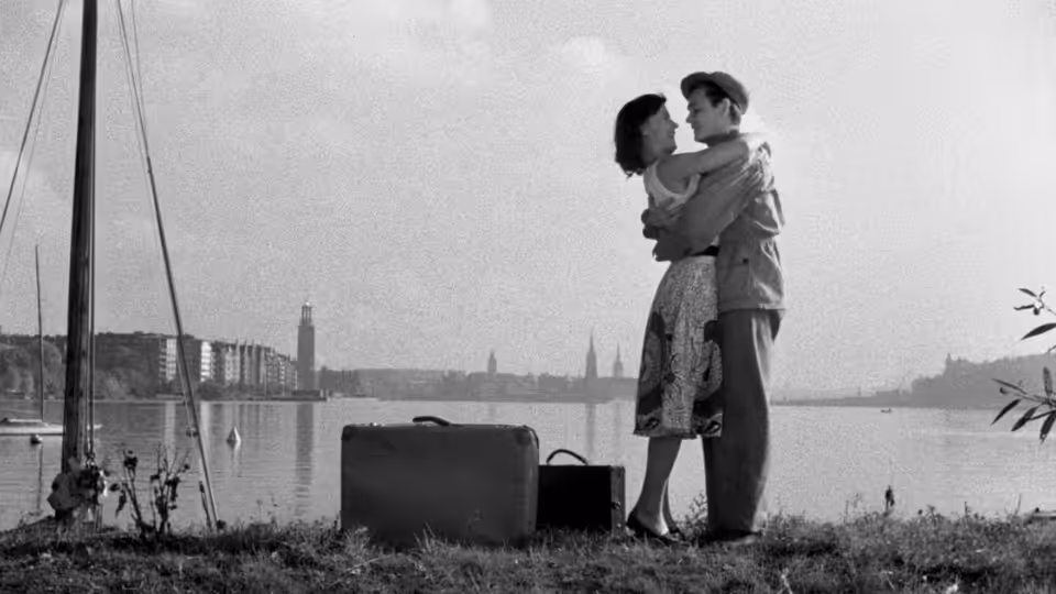 Monika (Harriet Andersson) and Harry (Lars Ekborg) embrace beside their luggage on a waterfront