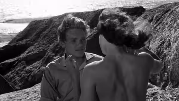 Harry (Lars Ekborg) faces Monika (Harriet Andersson) among seaside rocks