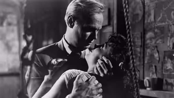 Skip McCoy (Richard Widmark) embraces Candy (Jean Peters) in a room