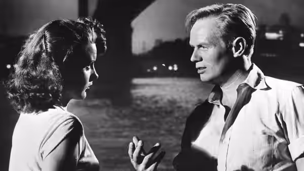 Candy (Jean Peters) and Skip McCoy (Richard Widmark) talk beside the water