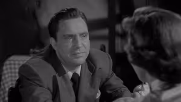 Harry Graham (Edmond O'Brien) leans forward, speaking with a woman across the table