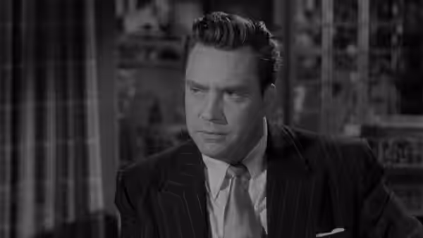 Harry Graham (Edmond O'Brien) sits alone in an office