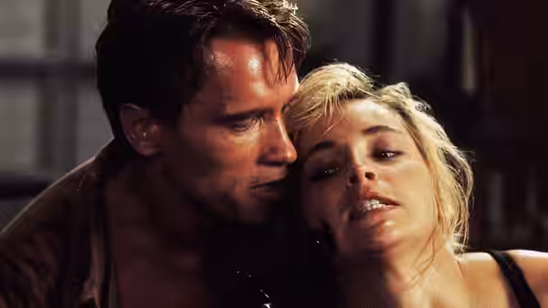 Quaid (Arnold Schwarzenegger) holding an injured woman close to his face