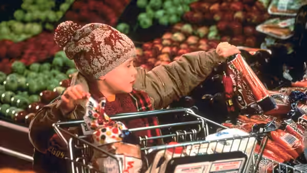 Kevin (Macaulay Culkin) reaching for groceries from a supermarket cart