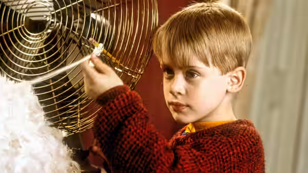 Kevin (Macaulay Culkin) holding thread beside a spinning fan