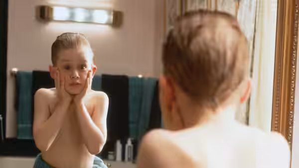 Kevin (Macaulay Culkin) checking his face in a bathroom mirror