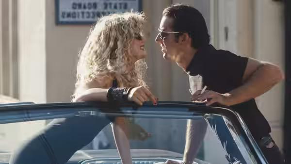 Lula (Laura Dern) and Sailor (Nicolas Cage) talking beside a convertible outdoors