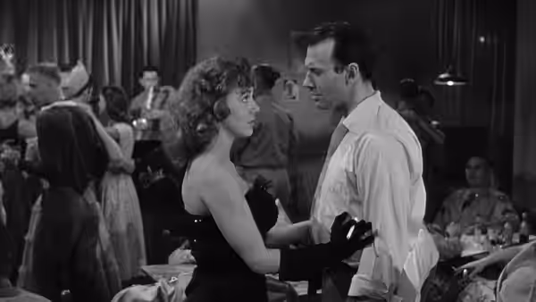 A couple face each other on a crowded dance floor