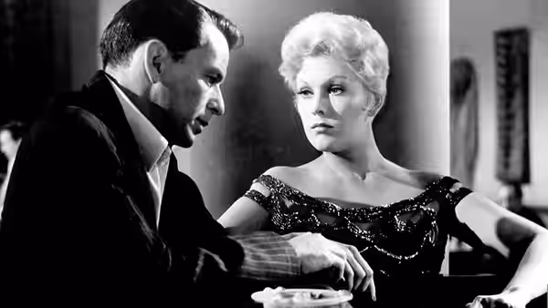 Frankie Machine (Frank Sinatra) and Molly (Kim Novak) sit together at a card table