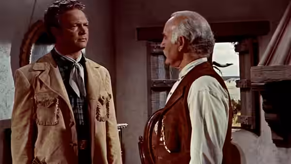 Will Lockhart (James Stewart) faces an older man inside a ranch building