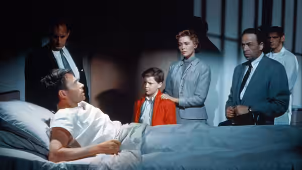 Ed Avery (James Mason) lies in a hospital bed as Lou, Richie and two doctors gather around him