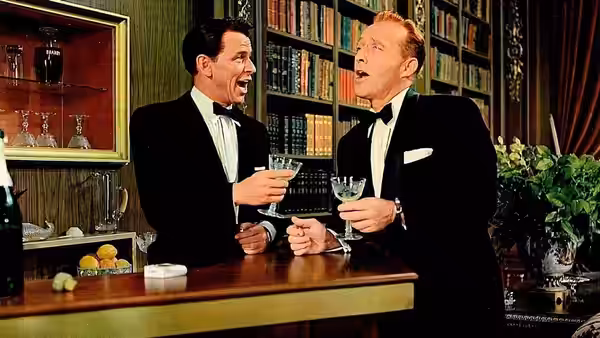 Mike Connor (Frank Sinatra) and C. K. Dexter-Haven (Bing Crosby) laugh together over drinks in the library