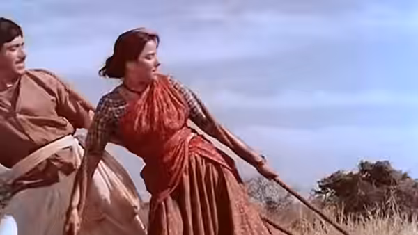 A woman pulls a rope beside a man in the open countryside