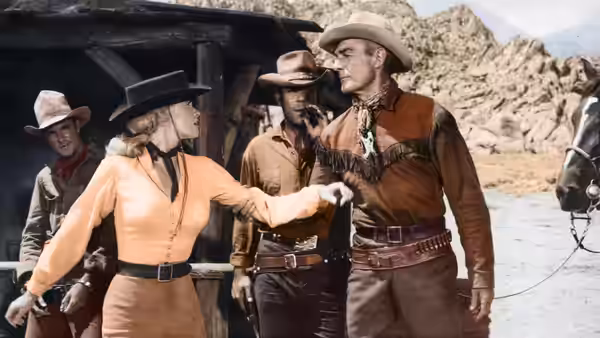 Carrie Lane (Karen Steele) gestures toward Ben Brigade (Randolph Scott) beside a wagon