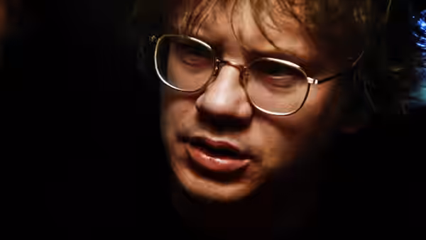 Jacob (Tim Robbins) with glasses looking upward in dim light
