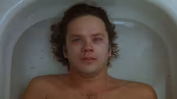 Jacob (Tim Robbins) lying in a white bathtub