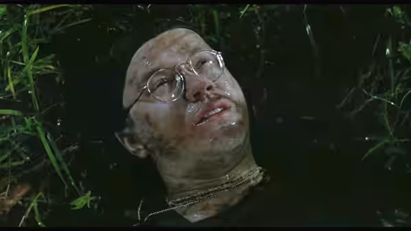 Man with glasses lying injured on the ground