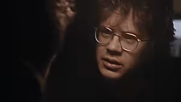 Jacob (Tim Robbins) with glasses speaking in shadow