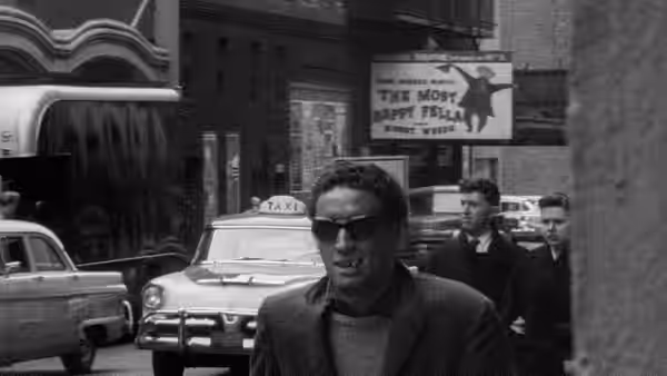 Ben (Ben Carruthers) walks past a taxi with two men following behind