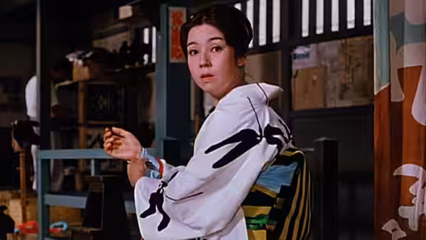 A woman in a white kimono turns toward the doorway inside a room