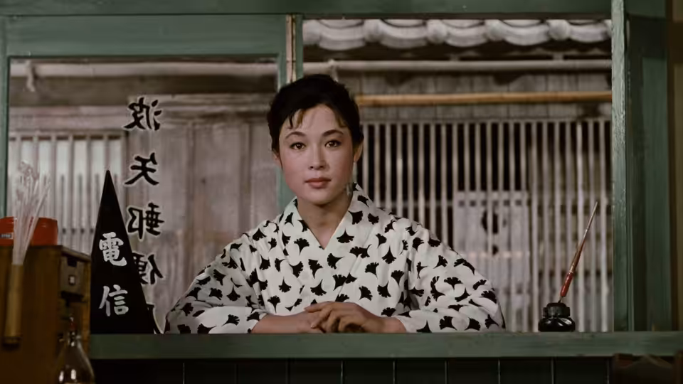 A woman sits behind a counter beneath a theater sign