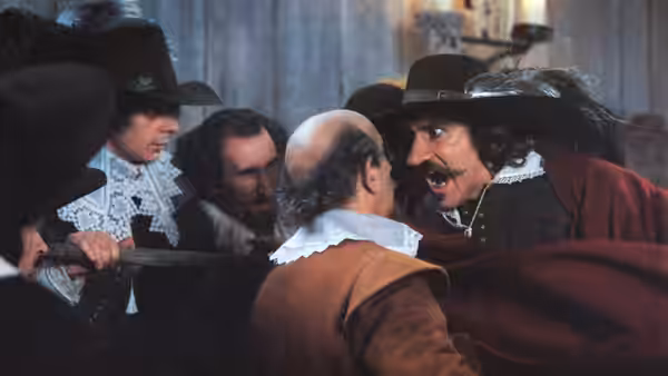 Cyrano (Gérard Depardieu) confronting men while holding a sword