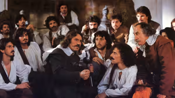 Cyrano (Gérard Depardieu) writing with a quill among a group of men