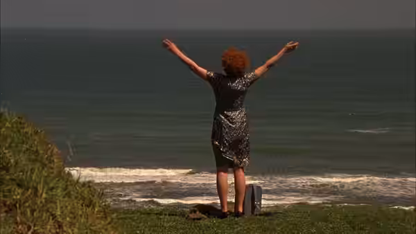 Janet Frame (Kerry Fox) standing with arms outstretched by the ocean