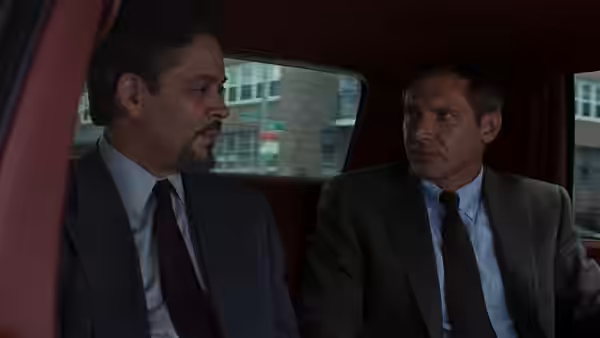 Sandy Stern (Raul Julia) and Rusty Sabich (Harrison Ford) in a car