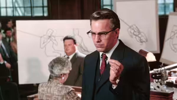 Jim Garrison (Kevin Costner) gesturing in a courtroom with diagrams