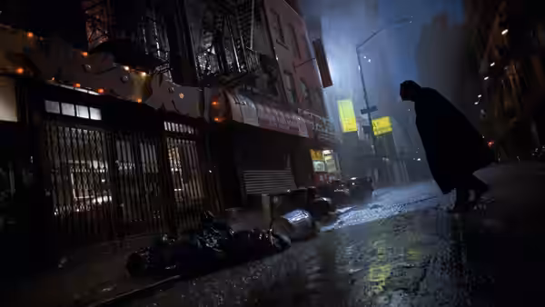 A cloaked figure walks alone on a wet city street at night