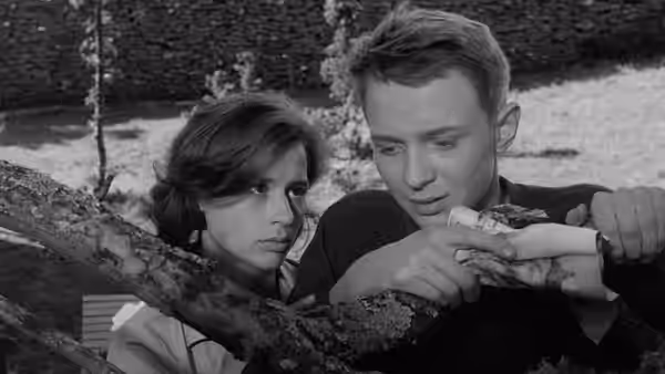 Karin (Harriet Andersson) and Minus (Lars Passgård) examine a small object outdoors
