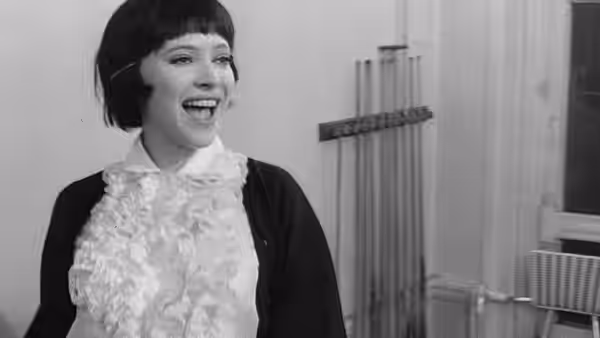 Nana Kleinfrankenheim (Anna Karina) laughs in a room