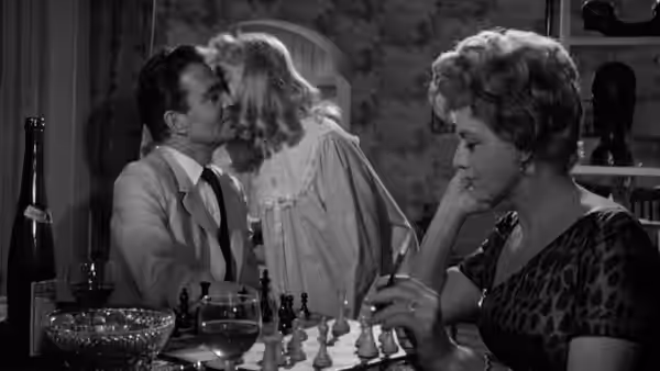 Humbert Humbert (James Mason) kisses Lolita (Sue Lyon) as Charlotte watches at dinner