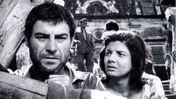 Zé do Burro (Leonardo Villar) grips the wooden cross while Rosa (Glória Menezes) watches beside him