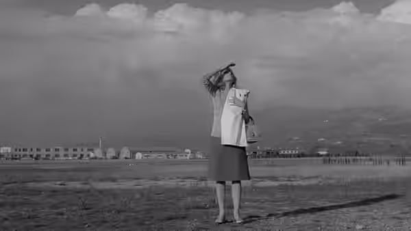 Vittoria (Monica Vitti) stands on an airfield, shading her eyes as she looks into the distance