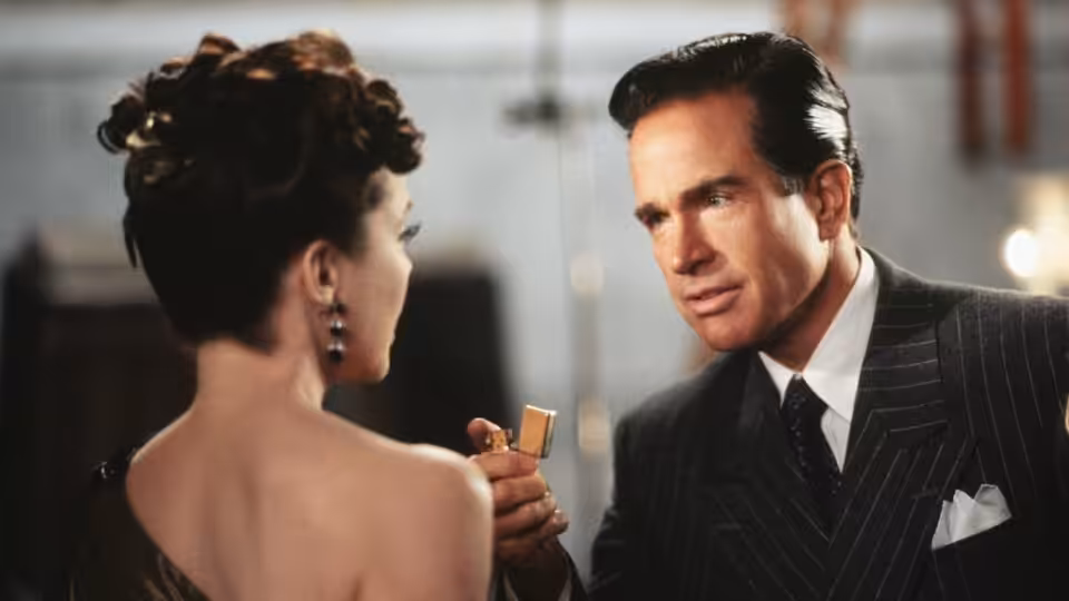 Virginia Hill (Annette Bening) facing Ben 'Bugsy' Siegel (Warren Beatty) as he holds a lighter