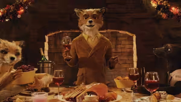 A fox in a brown suit raises a glass of wine at a long dinner table with other animals