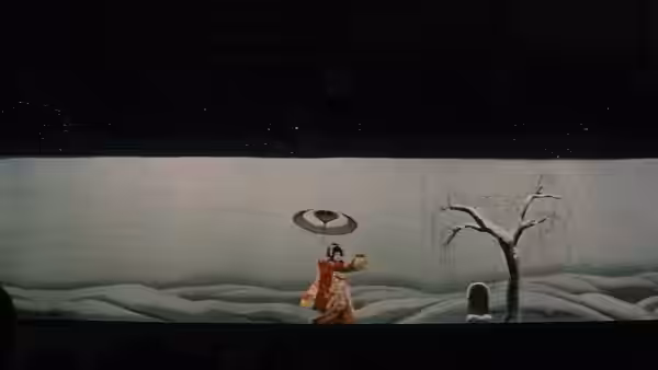 A small figure in an orange robe stands before a snowy painted landscape