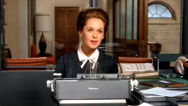 Marnie Edgar (Tippi Hedren) sits behind an office typewriter