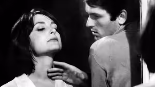 A man reaches toward a woman’s neck as she tilts her head back