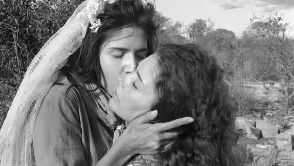 Rosa (Yoná Magalhães) cradles Manoel (Geraldo del Rey) as they kiss outdoors