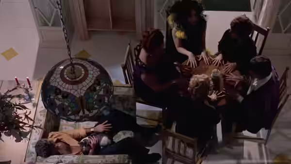 A group reaches across a dining table as Giulietta lies beside it