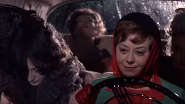 Giulietta (Giulietta Masina) drives a car among shadowed passengers