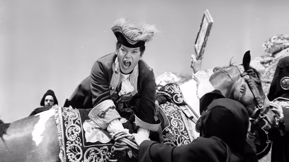 Alfonse Van Worden (Zbigniew Cybulski) shouts from a carriage surrounded by masked figures