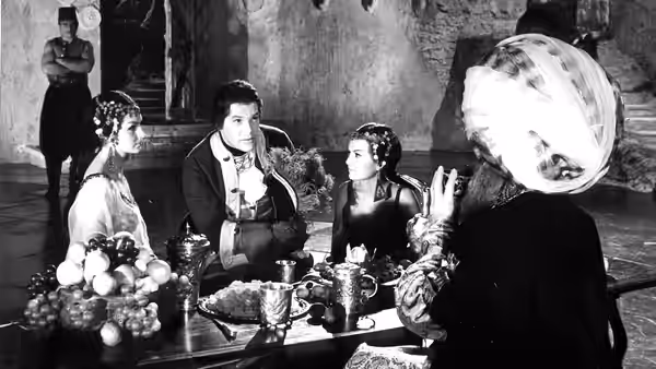 Alfonse Van Worden (Zbigniew Cybulski) speaks with two women at a table as another watches