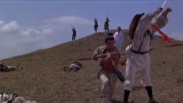 Martial artists clash on a hillside as fallen fighters lie across the ground
