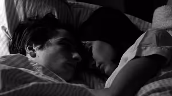Paul (Jean-Pierre Léaud) lies close beside a woman under the covers