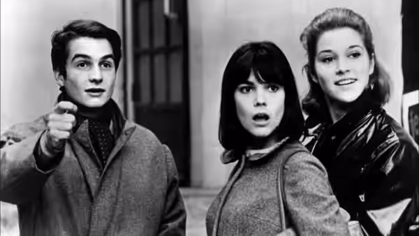 Paul (Jean-Pierre Léaud) points ahead as Madeleine Zimmer (Chantal Goya) and Élisabeth Choquet (Marlène Jobert) look on
