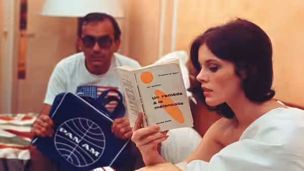 A woman reads a pamphlet while a man holds up printed materials